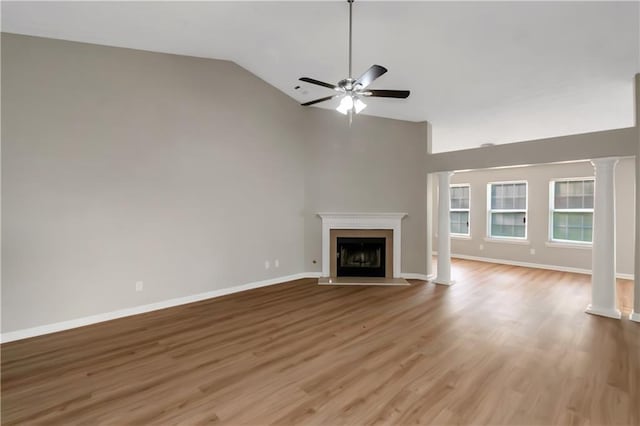 1011 Riverclift Dr, Covington, GA 30016 - unfurnished living room featuring ornate columns, ceiling fan, a fireplace, light wood-type flooring, and high vaulted ceiling
