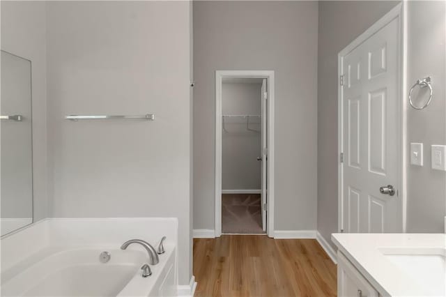 1011 Riverclift Dr, Covington, GA 30016 - bathroom featuring a bath, wood finished floors, vanity, and baseboards