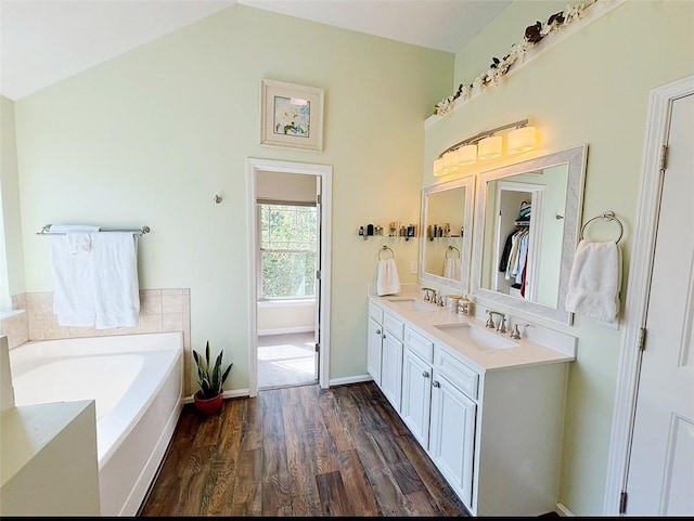 57 Matador, Newnan, GA 30263 - bathroom with double vanity, a garden tub, lofted ceiling, wood finished floors, and baseboards