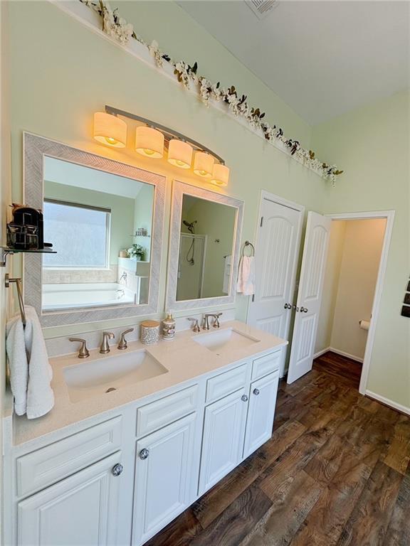 57 Matador, Newnan, GA 30263 - bathroom with a bath, a shower stall, wood finished floors, and double vanity