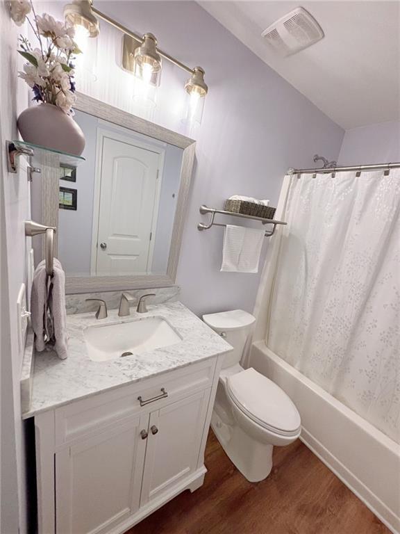 57 Matador, Newnan, GA 30263 - bathroom featuring wood finished floors, vanity, toilet, and shower / tub combo