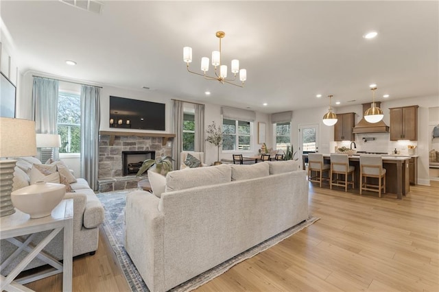 living room with a wealth of natural light, a fireplace, and light hardwood / wood-style flooring