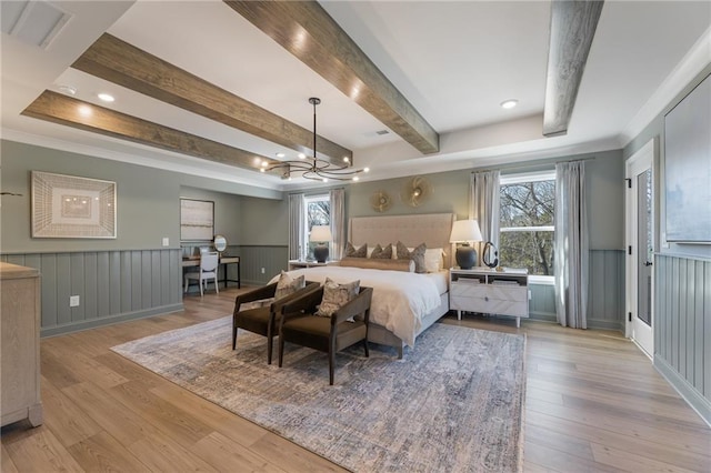 bedroom with multiple windows, beam ceiling, and light hardwood / wood-style flooring