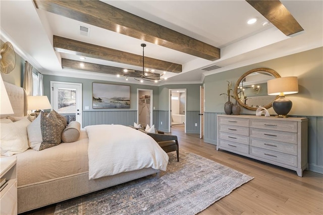 bedroom featuring ensuite bath, an inviting chandelier, a raised ceiling, beamed ceiling, and light wood-type flooring