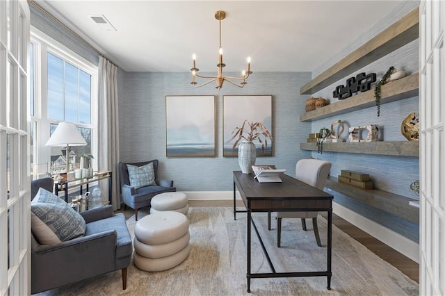 office with hardwood / wood-style flooring and a notable chandelier