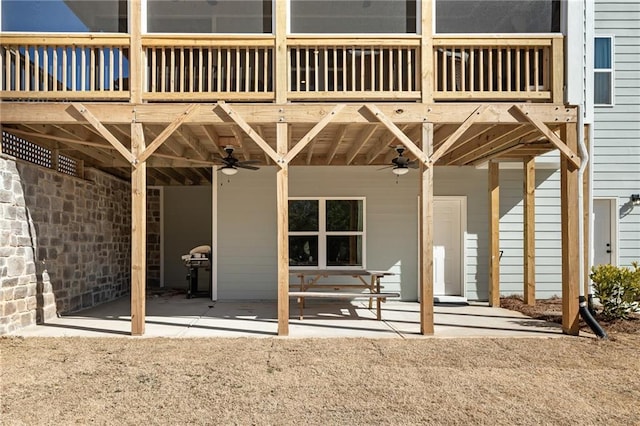 back of house with ceiling fan, a balcony, and a patio area