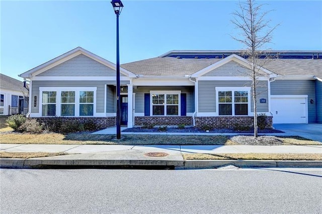 view of front of house featuring concrete driveway, brick siding, and an attached garage