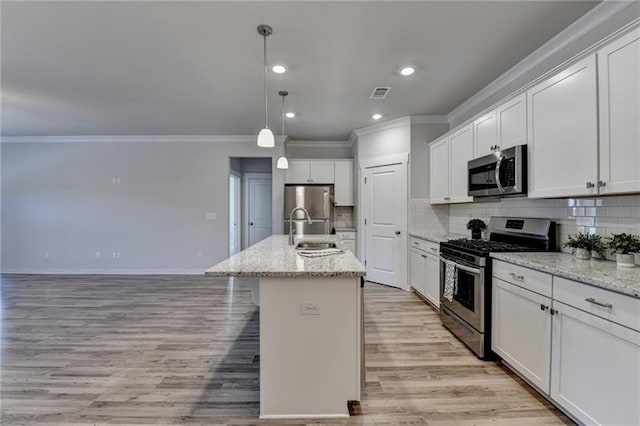 kitchen featuring appliances with stainless steel finishes, visible vents, a sink, and backsplash