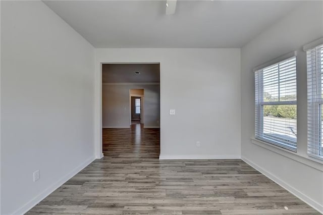 empty room with baseboards and wood finished floors