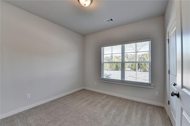 carpeted spare room featuring visible vents and baseboards