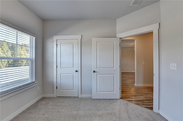 unfurnished bedroom featuring light colored carpet, visible vents, and baseboards