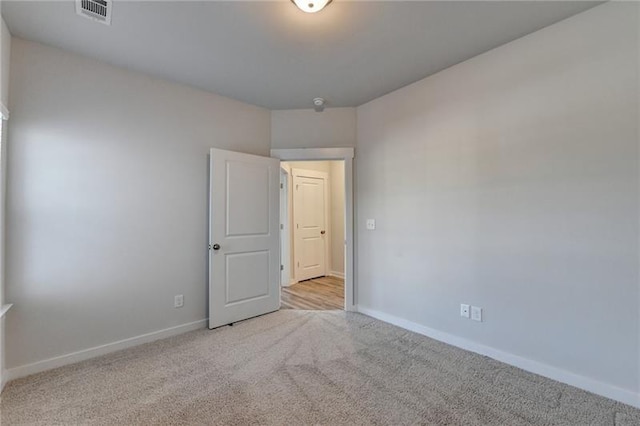 empty room featuring baseboards, visible vents, and carpet flooring