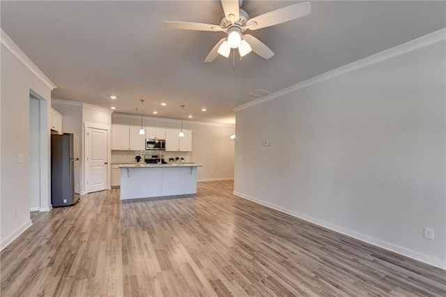 unfurnished living room featuring light wood-style floors, ceiling fan, baseboards, and crown molding