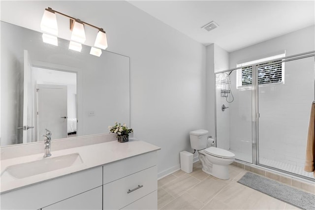 bathroom featuring a shower with shower door, vanity, tile patterned floors, and toilet