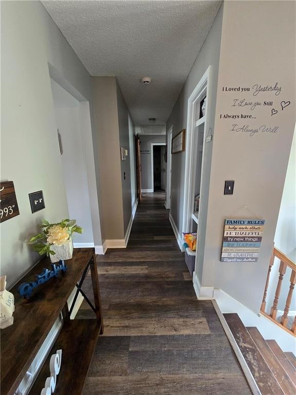 hall with dark hardwood / wood-style floors and a textured ceiling