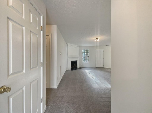 unfurnished living room with carpet and a textured ceiling