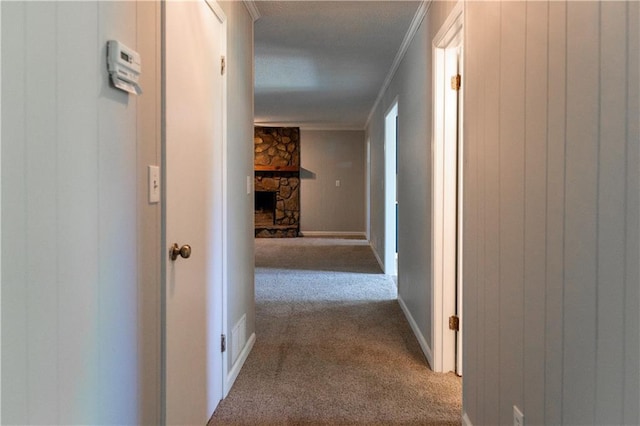 hall with carpet flooring, crown molding, and baseboards