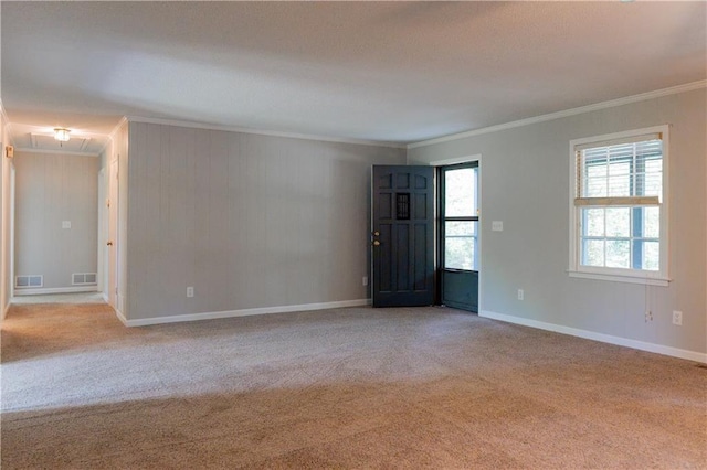 unfurnished room featuring ornamental molding, light carpet, baseboards, and attic access