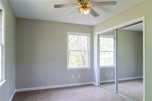 unfurnished bedroom featuring carpet flooring, baseboards, a closet, and ceiling fan