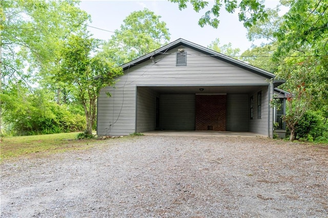 garage with gravel driveway and a carport