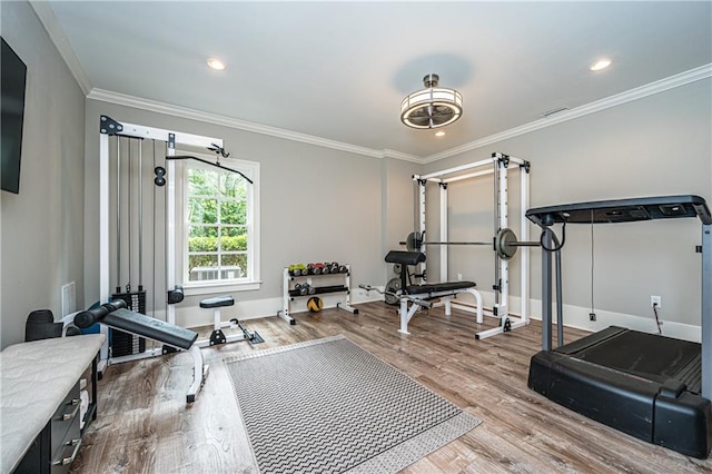 exercise area with crown molding and hardwood / wood-style floors