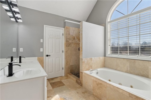 bathroom with a sink, tiled shower, lofted ceiling, and a tub with jets