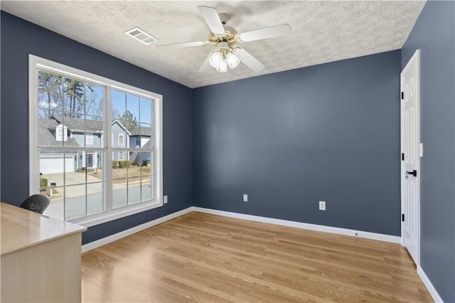 empty room with visible vents, baseboards, ceiling fan, and light wood finished floors