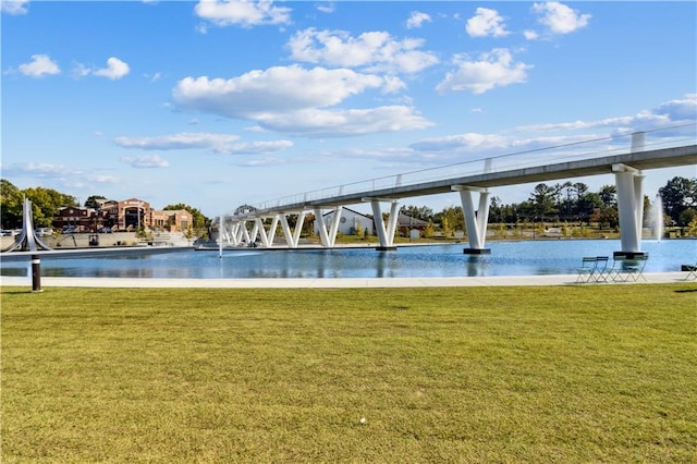 view of pool featuring a yard and a water view