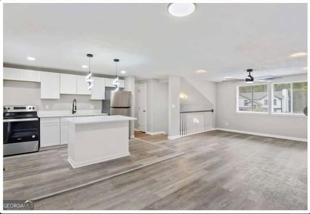 2106 Singer Way, Lithonia, GA 30058 - kitchen featuring stainless steel appliances, white cabinetry, a center island, light countertops, and a ceiling fan