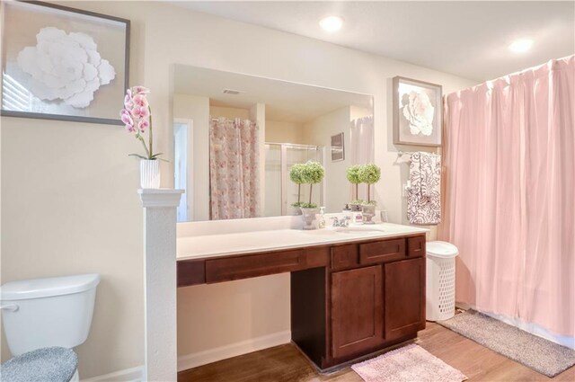 bathroom with vanity, hardwood / wood-style flooring, toilet, and walk in shower