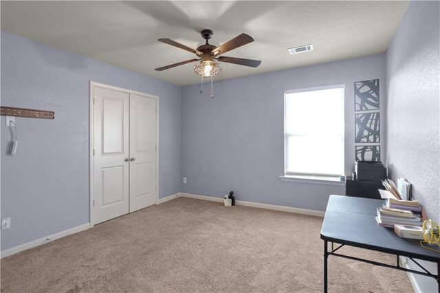 carpeted office with ceiling fan