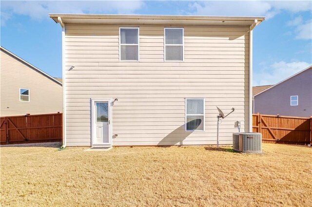 back of property with a yard and central AC unit