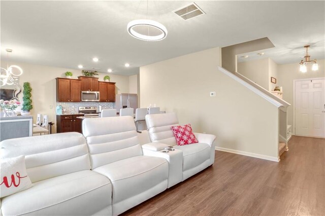 living room with dark hardwood / wood-style floors and a chandelier