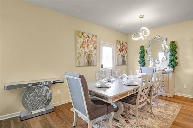 dining area featuring hardwood / wood-style flooring and a chandelier