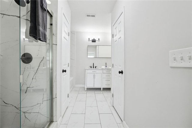 912 Ira St SW, Atlanta, GA 30310 - full bathroom featuring marble look tile flooring, a marble finish shower, vanity, and baseboards