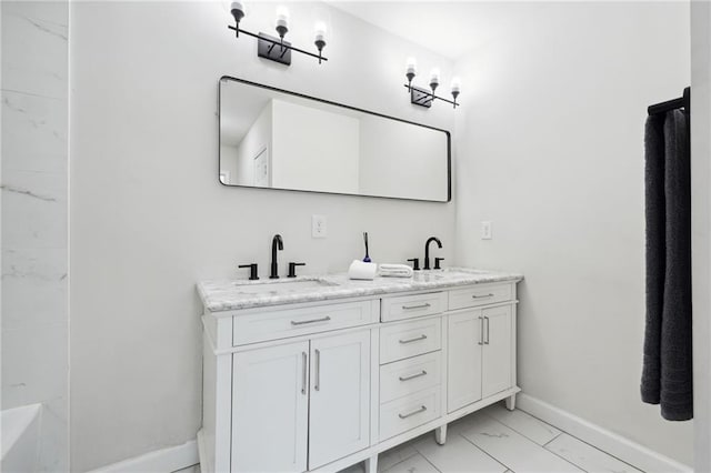 912 Ira St SW, Atlanta, GA 30310 - bathroom featuring marble look tile flooring, double vanity, and baseboards