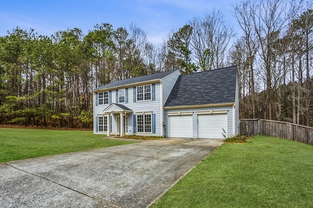 colonial house with a front yard, fence, a garage, and driveway