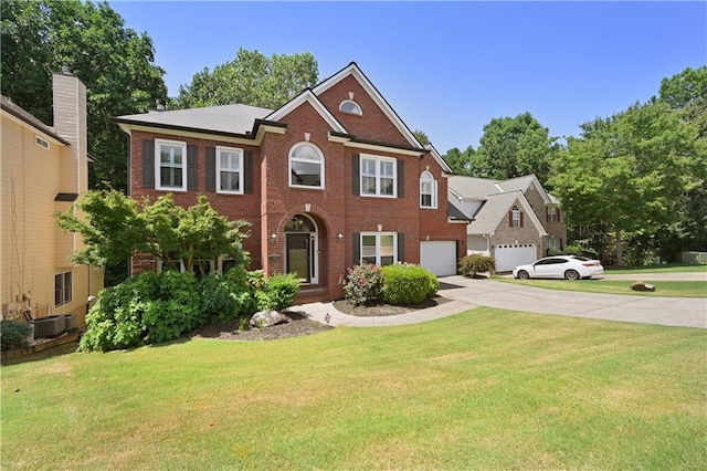 colonial home with brick siding, an attached garage, a front yard, central AC unit, and driveway