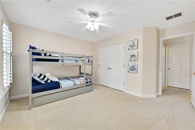 carpeted bedroom with a closet and ceiling fan