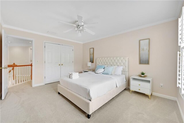 carpeted bedroom with a closet, ceiling fan, and crown molding