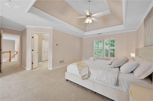 carpeted bedroom featuring ceiling fan, a raised ceiling, and ornamental molding