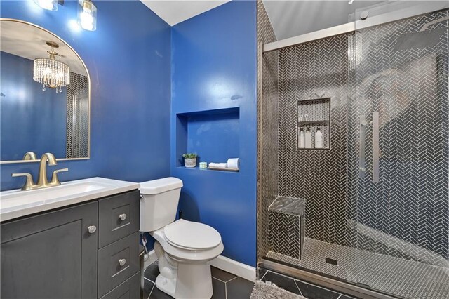 bathroom featuring tiled shower, vanity, toilet, and tile patterned flooring