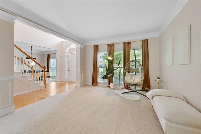 living area with crown molding, hardwood / wood-style floors, and decorative columns