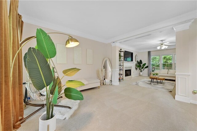 sitting room with light carpet, ceiling fan, and crown molding