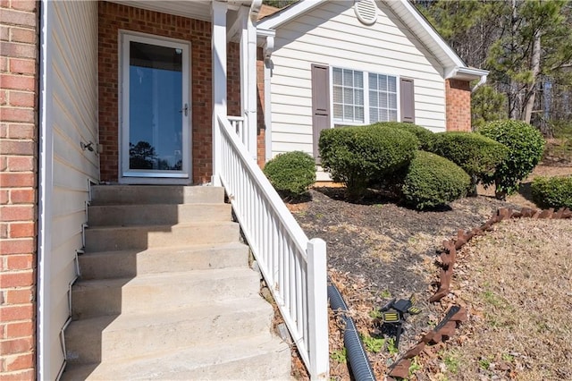 view of exterior entry featuring brick siding