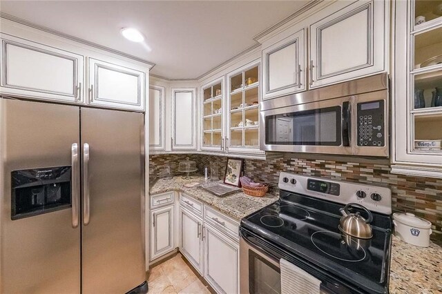 kitchen featuring light stone countertops, appliances with stainless steel finishes, and backsplash