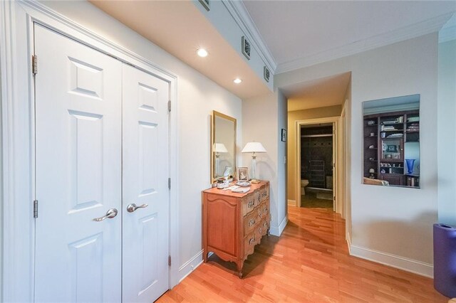 corridor featuring crown molding and light hardwood / wood-style floors