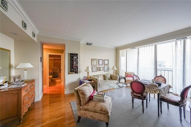 living room featuring light hardwood / wood-style floors and ornamental molding