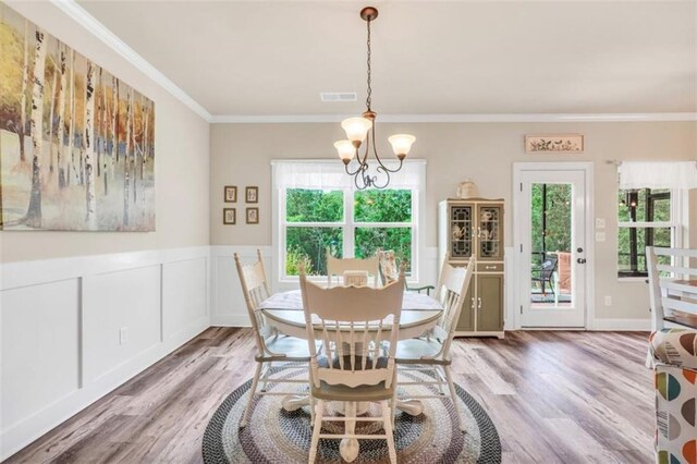 210 Riverpoint Way, Jackson, GA 30233 - dining room featuring a chandelier, ornamental molding, light wood-type flooring, a wainscoted wall, and a decorative wall