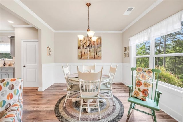 210 Riverpoint Way, Jackson, GA 30233 - dining room featuring healthy amount of natural light, a chandelier, light wood-style flooring, ornamental molding, and wainscoting
